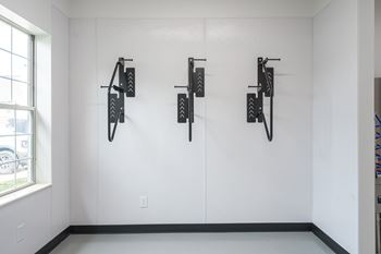 Black bike racks are mounted on a white wall